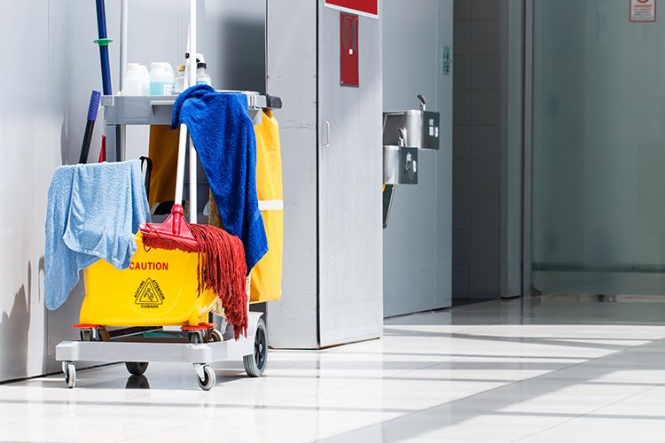Reinigungswagen mit Mopp und Tüchern in einem sauberen Flur